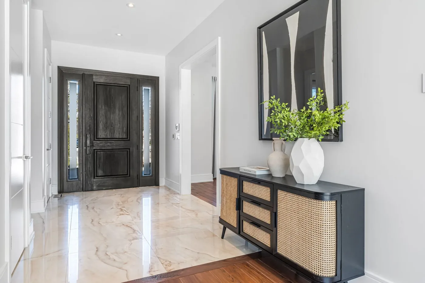 A marble front hall with a dark wood door